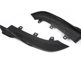 Two carbon fiber car parts with curved designs rest on a white background, featuring multiple mounting points.