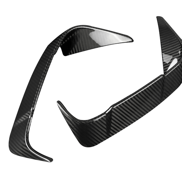 Two carbon fiber car parts with a sleek, aerodynamic design are positioned against a plain white background, displaying a glossy, reflective surface pattern.