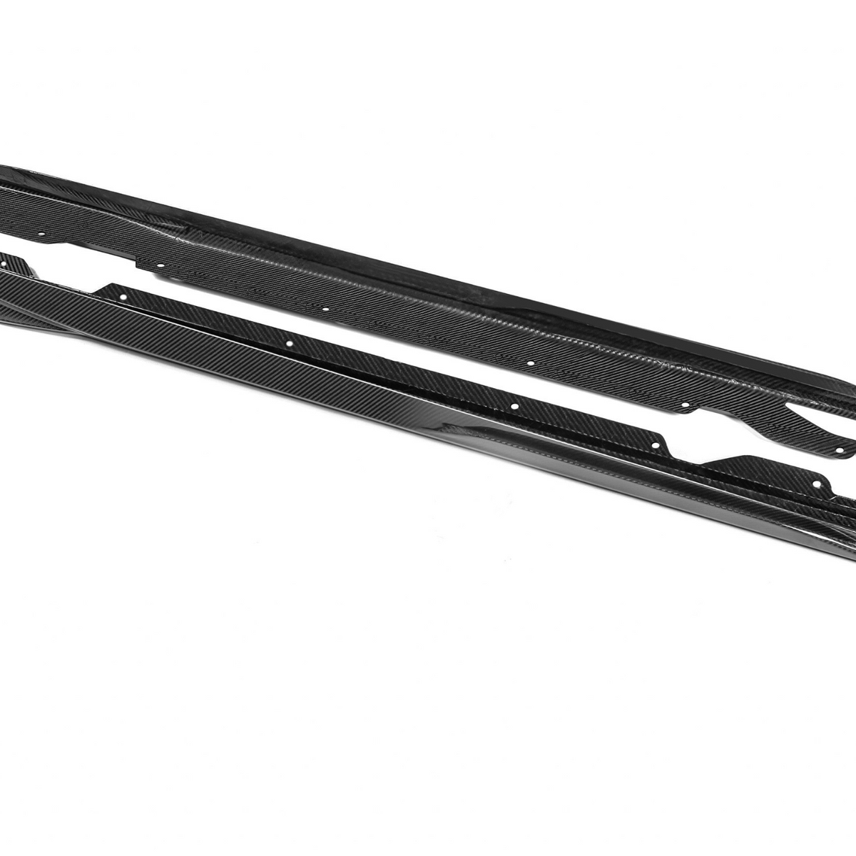 Carbon fiber car side skirts rest on a white surface. The upper skirt is slightly elevated, while the lower one is flat. The label reads "Spoon" in the corner.