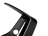 A carbon fiber car part features a curved, aerodynamic design with a circular hole, set against a plain white background.