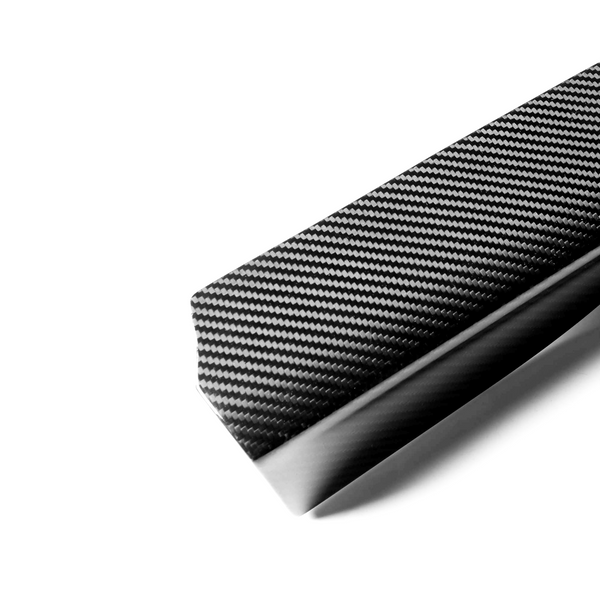 A carbon fiber bar with a glossy, woven texture rests on a plain white background, highlighting its sleek, modern design.