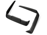Two black carbon fiber car splitters are positioned on a plain white background, showcasing their glossy surface and aerodynamic design features.