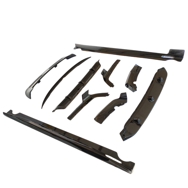 Car body kit components arranged on a white surface, including various sleek, black aerodynamic parts such as side skirts, spoilers, and diffusers, designed to enhance vehicle performance and appearance.