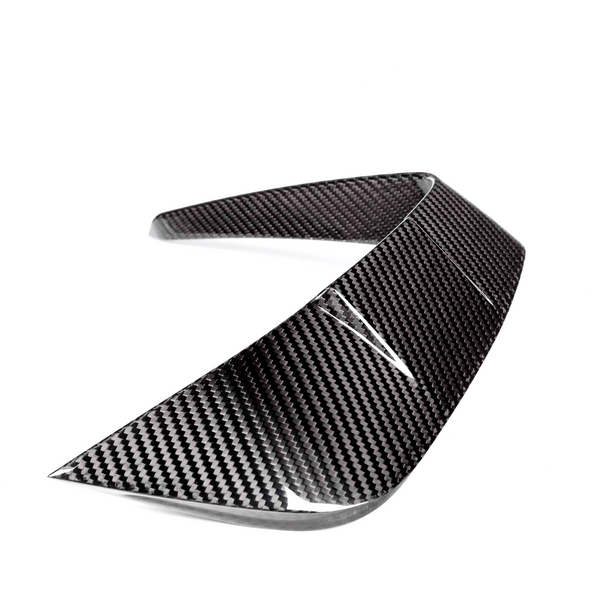 A carbon fiber car spoiler curves upward, designed for aerodynamic enhancement, displayed against a white background.