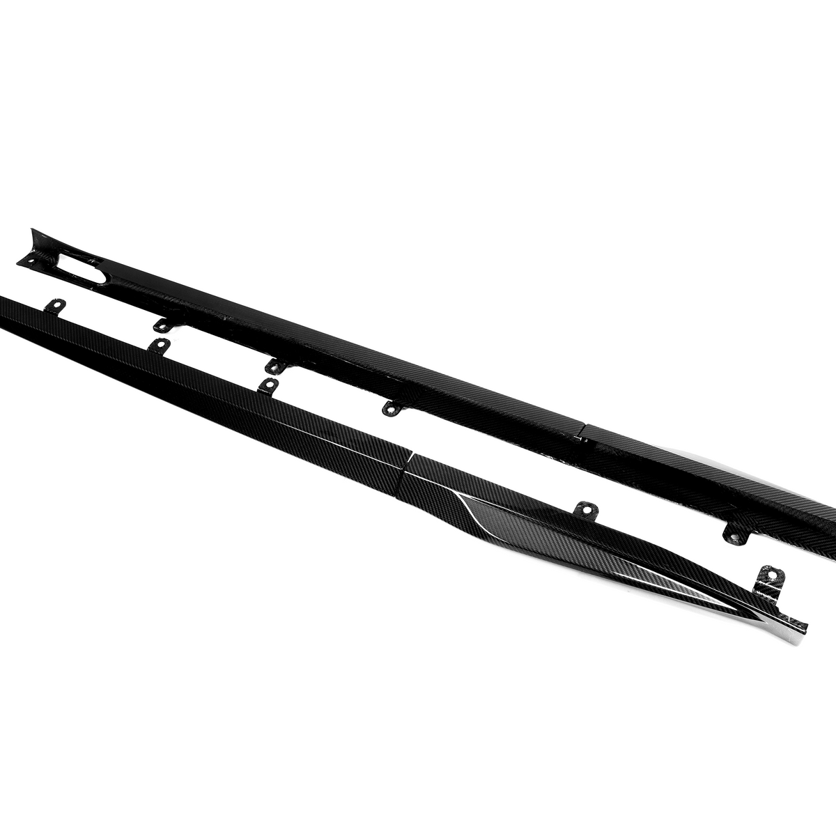 Two elongated, black carbon fiber side skirts with mounting brackets lie parallel on a plain white background, designed for automotive use, enhancing aerodynamic performance.