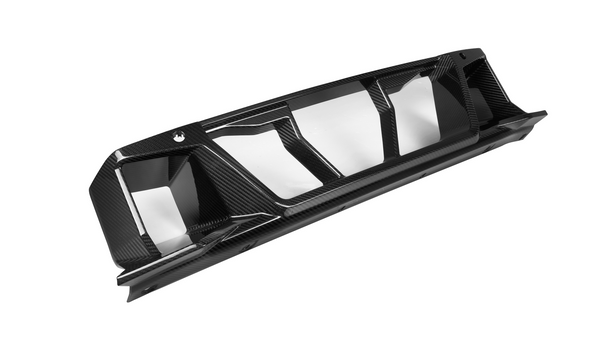 A black, carbon fiber car diffuser with sleek, angular fins designed for aerodynamic performance, placed on a plain white background.