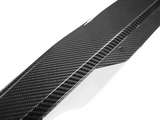 A sleek carbon fiber car component with a checkered pattern features bolt holes for attachment, set against a plain white background.