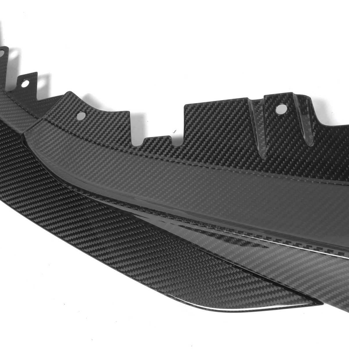 A carbon fiber car panel with textured surface and notched edge lies on a plain white background, showcasing detailed craftsmanship and modern design elements.