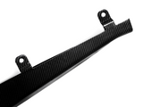 A carbon fiber component with two mounting holes, angled and shiny, rests against a white background, highlighting its sleek and lightweight design.