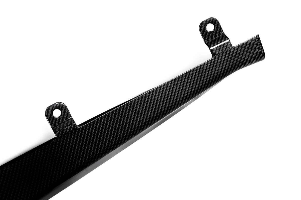 A carbon fiber component with two mounting holes, angled and shiny, rests against a white background, highlighting its sleek and lightweight design.