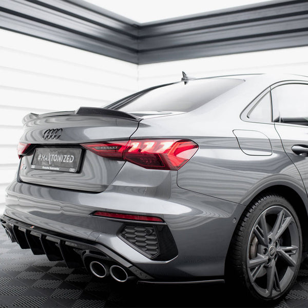 A sleek silver car is parked in a modern showroom. The backplate reads "#MAYTONIZED Paweł Świątek." The vehicle features distinctive taillights and dual exhaust pipes.