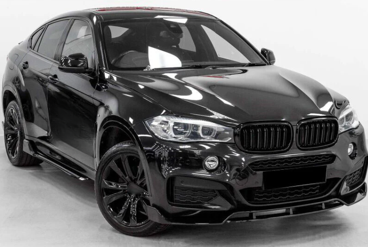 A black luxury SUV with sleek design features and large wheels is parked in a well-lit, plain indoor space, highlighting its glossy exterior and modern detailing.