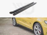 Two black car side skirts are displayed above a yellow Audi with silver wheels parked on gravel. The car has 