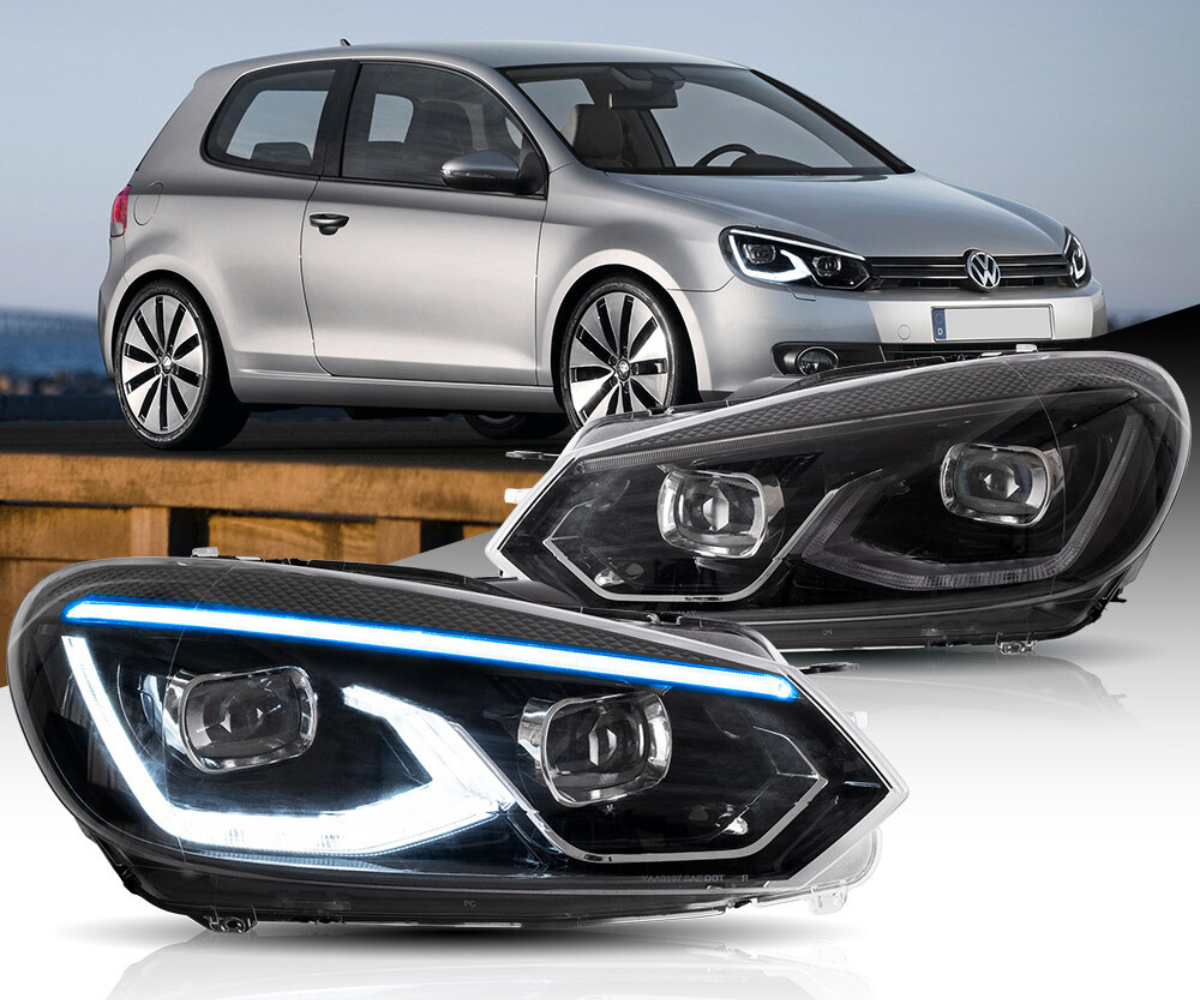 Headlights are prominently displayed with LED detailing against a backdrop of a parked silver car. The vehicle, a three-door hatchback, is situated outdoors on a wooden surface.