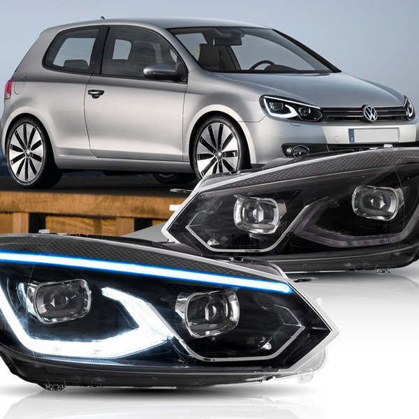 Headlights are prominently displayed with LED detailing against a backdrop of a parked silver car. The vehicle, a three-door hatchback, is situated outdoors on a wooden surface.