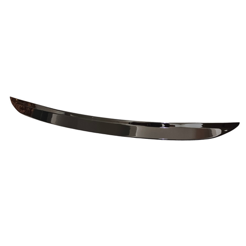A shiny, curved strip of metal lies horizontally against a plain white background, with no visible features beyond its polished surface.