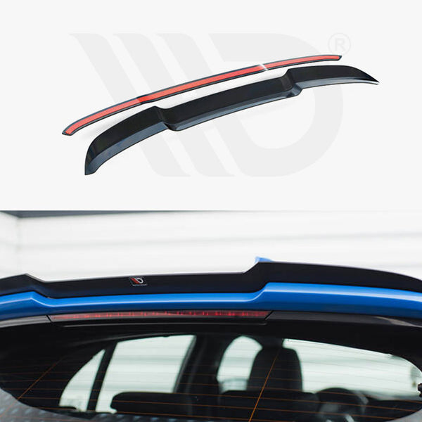 Rear vehicle spoiler, positioned on a blue car, enhances aerodynamics. The upper section shows the spoiler design with a red accent, highlighting its sleek shape. Indoor garage setting.