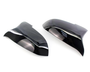 Black, glossy car mirror covers are shown lying side by side on a white background, reflecting light and their smooth, curved design.