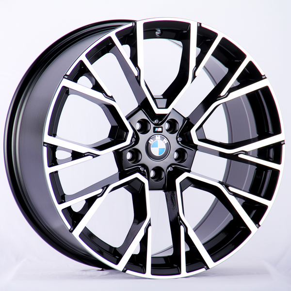 A BMW car wheel rim is displayed against a plain white background, featuring a modern, intricate black and silver geometric design with the BMW logo at the center.