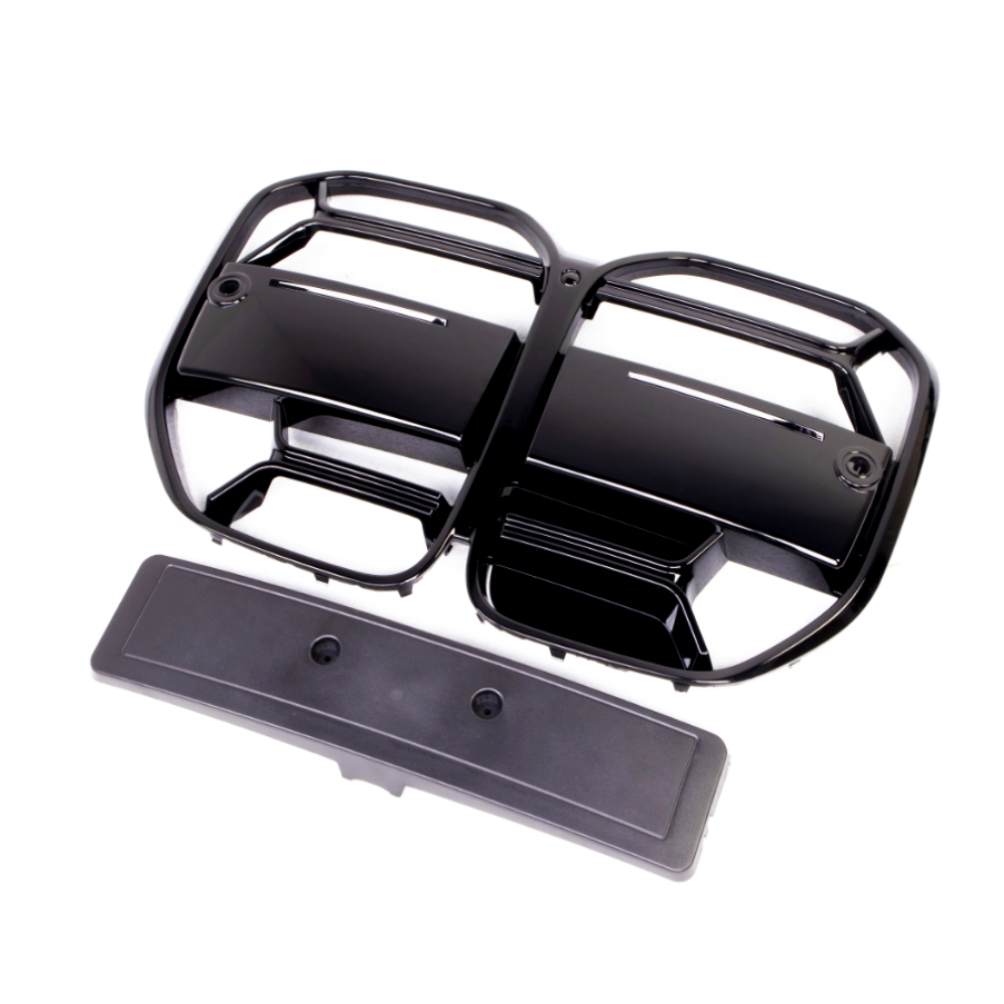 Black plastic vent covers with multiple horizontal slats are positioned on a white background. They appear detached and are accompanied by a long, rectangular panel below.