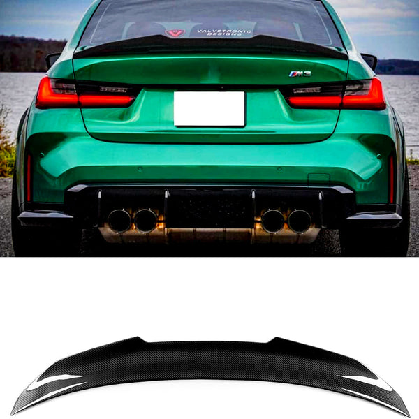 Green car with a visible "M3" badge parked beside a lake; quad exhausts below. Rear window displays “VALVETRONIC DESIGNS.” Below, a black carbon fiber spoiler appears on a white background.
