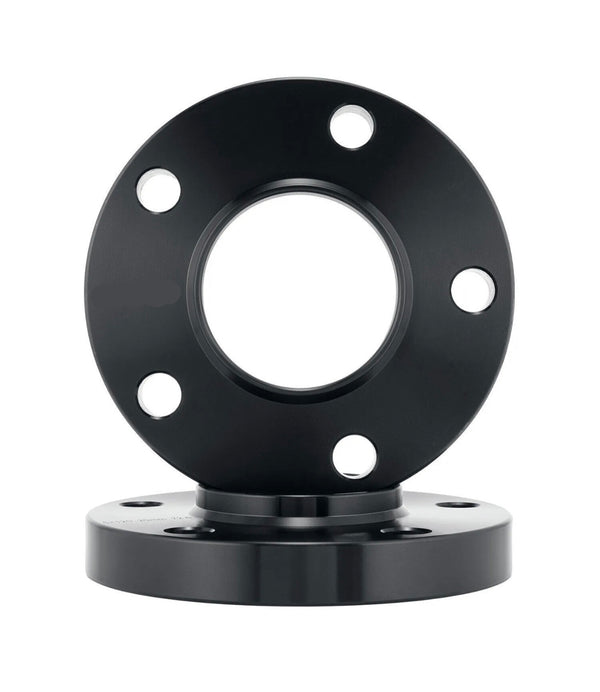 Black metal flange with a circular shape, featuring four evenly spaced bolt holes, rests vertically on another identical flange. The background is plain white, highlighting the object.