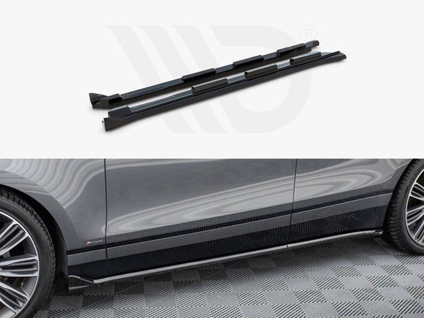 Two black side skirts are displayed above a partial view of a gray car parked on a patterned floor. The side skirts are aligned with the car's lower edge.