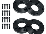 Four black wheel spacers with multiple bolt holes lay arranged symmetrically. Beside them, twenty-four black bolts stand in three vertical rows, contrasting the plain white background.