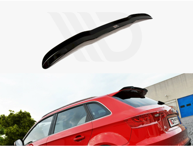 Black car spoiler displayed separately above a red SUV. The spoiler is aerodynamically designed, while the SUV is parked outdoors near a building with a tree in the background.