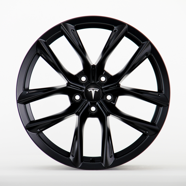 A black wheel rim featuring a sleek, multi-spoke design with the Tesla logo visible at the center, placed against a plain white background.