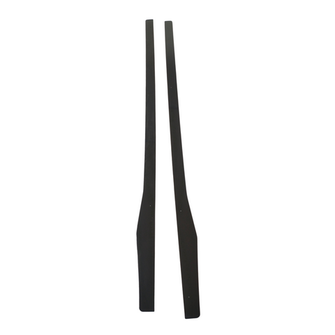 Two black, elongated wooden pieces are standing vertically side by side against a plain white background. They are symmetrical and have tapered ends.