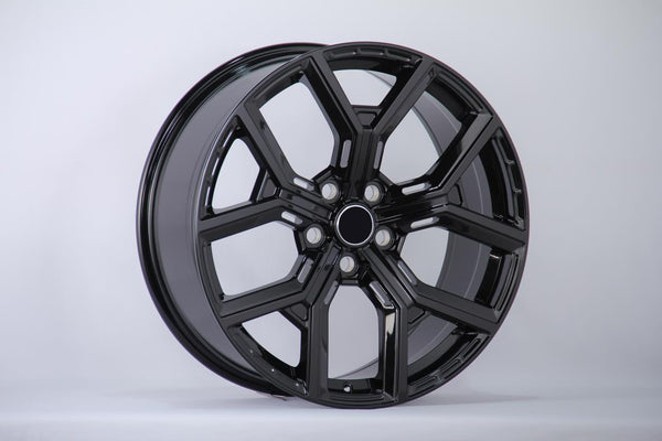 A sleek, glossy black alloy car wheel sits angled, displaying its intricate spoke design against a neutral gray background.