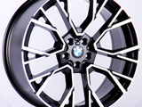 A sleek, black and silver alloy wheel with a BMW logo in the center, prominently displayed against a plain white background.