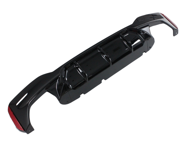 A black car bumper diffuser, positioned horizontally, features multiple aerodynamic fins and red reflective accents on a plain white background.