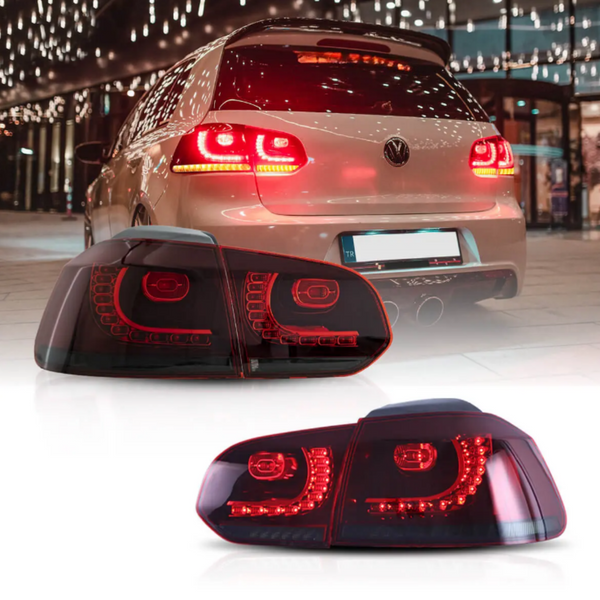 Car with glowing red taillights idling in a brightly lit urban setting; focus on a close-up view of the taillight design below, featuring multiple LED segments.