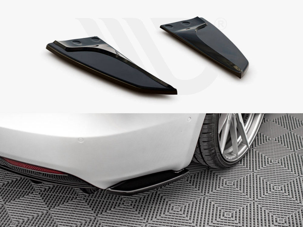 Two black aerodynamic fins positioned above, shown detached; below, they are installed on the rear of a white car, parked on patterned flooring, near a rear wheel.