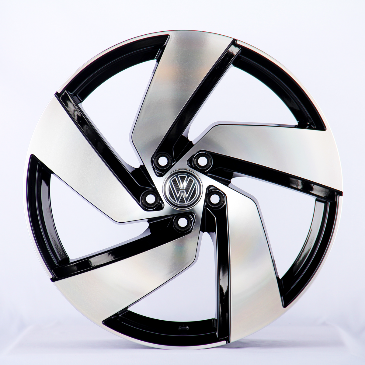 A metallic car wheel with a five-spoke design featuring a central logo; it rests against a plain white background.