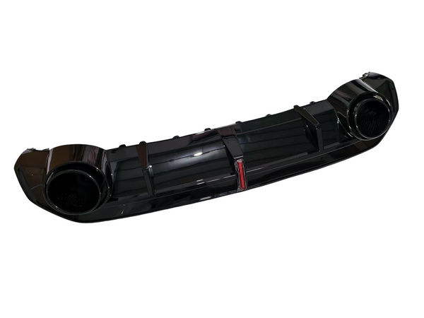 A glossy black car rear diffuser, featuring dual circular exhaust ports, lies isolated against a white background. The central section has vertical fins, enhancing aerodynamics.