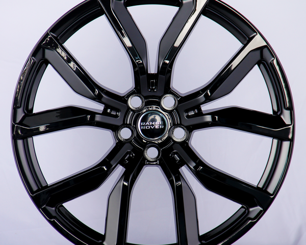 A glossy black alloy wheel with a five-double-spoke design, featuring the "Range Rover" logo at the center, displayed against a plain white background.