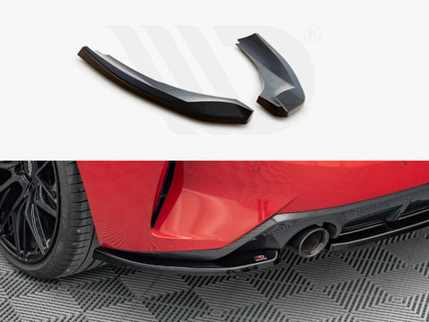 Two black car parts on a white background; below, one part is attached near the rear wheel and exhaust of a red car with black wheels on a patterned floor.