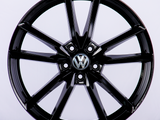 A glossy black car wheel rim with a Volkswagen logo at the center, featuring a split-spoke design, displayed against a plain white background.