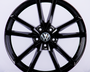 A glossy black car wheel rim with a Volkswagen logo at the center, featuring a split-spoke design, displayed against a plain white background.