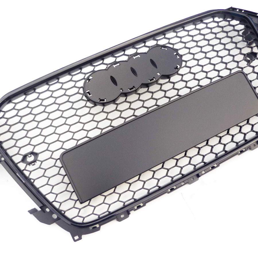 A black, hexagonal-patterned car grille with spaces for emblem attachment lies against a plain white background.
