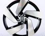 A metallic car wheel rim with a five-spoke design features a central logo containing a "VW" emblem, displayed against a plain white background.