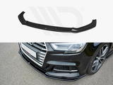 A black car front splitter, featuring aerodynamic contours, is shown separately and installed on a dark vehicle, enhancing its appearance and performance on a paved surface.