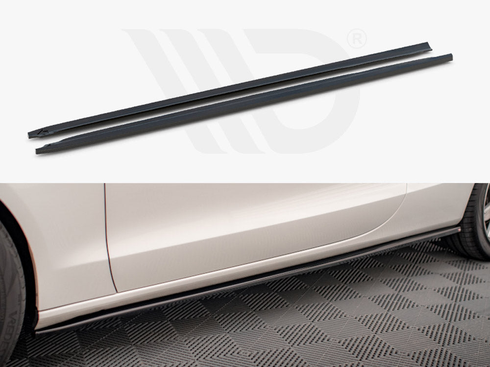 Two long, narrow black side skirt extensions displayed above the side profile of a white car. The car is parked on a textured floor, enhancing its sporty appearance.