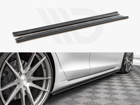 Two black side skirt extensions shown in detail above a photo of a silver car with them installed, positioned next to stylish alloy wheels on a patterned floor.