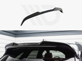 Black car roof spoiler installed on the rear of a vehicle, enhancing aerodynamics. The setting is a garage with gray and white walls, creating a sleek, modern atmosphere.