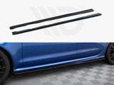 Two black side skirts sit above an image of a blue car's side with a fitted side skirt, on a textured gray floor.