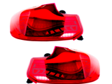 Two red car taillights, unlit, are displayed against a plain white background. Each taillight features intricate internal details and black mounting connectors.